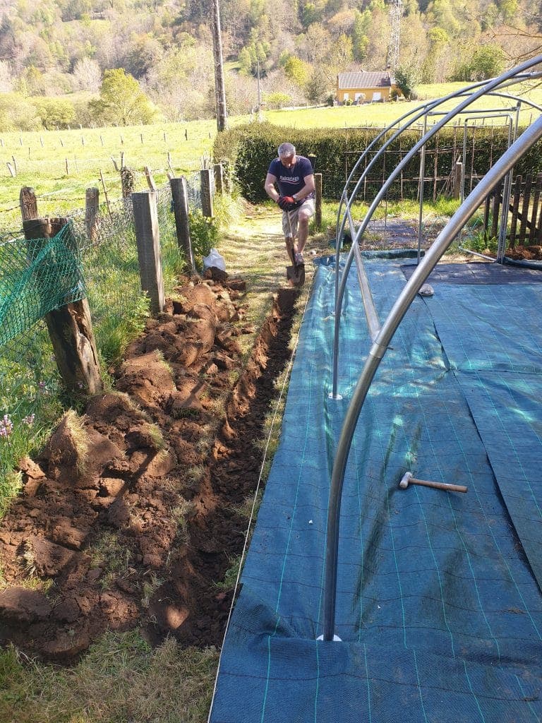 Excavar surcos para fijar la cubierta del invernadero en los laterales